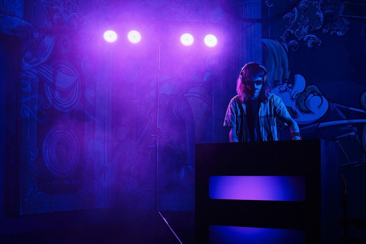 DJ bajo la luz morada de focos LED Ayra ComPar 2